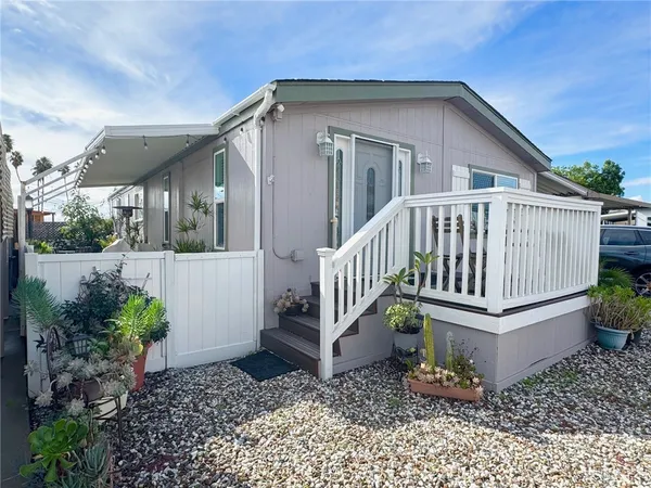 a view of a house with wooden deck and furniture