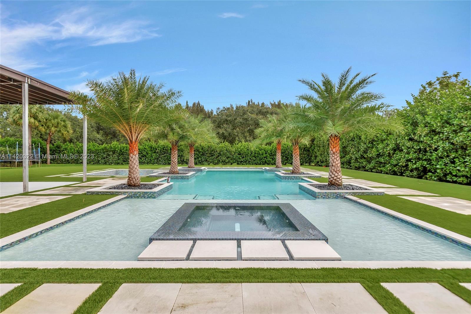 12887 Equestrian Trail Davie, FL 33330 - Photo 40 of 92 a view of a swimming pool with a yard and sitting area