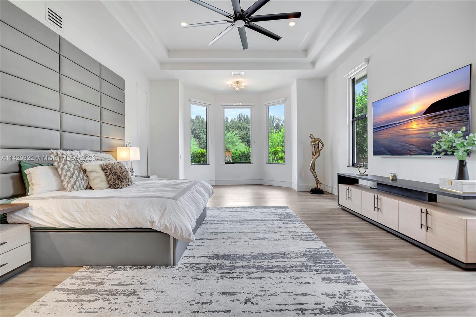 12887 Equestrian Trail Davie, FL 33330 - Photo 48 of 92 a spacious bedroom with a large bed and a flat screen tv