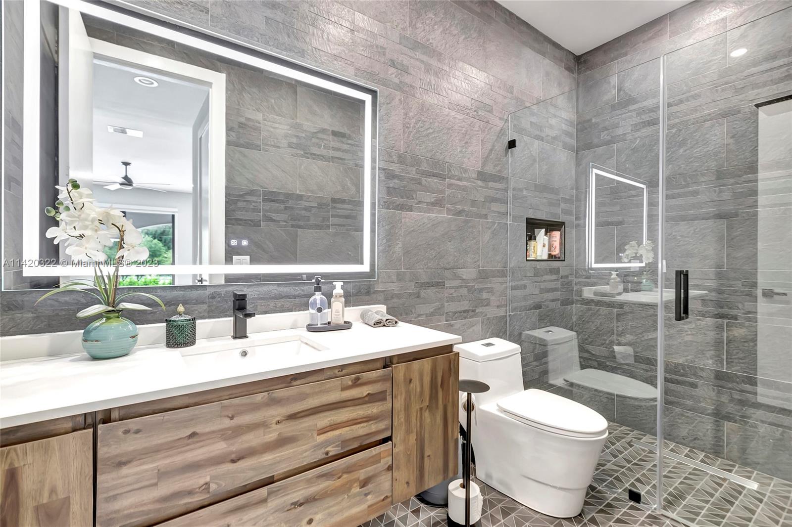 12887 Equestrian Trail Davie, FL 33330 - Photo 76 of 92 a bathroom with a toilet sink and mirror