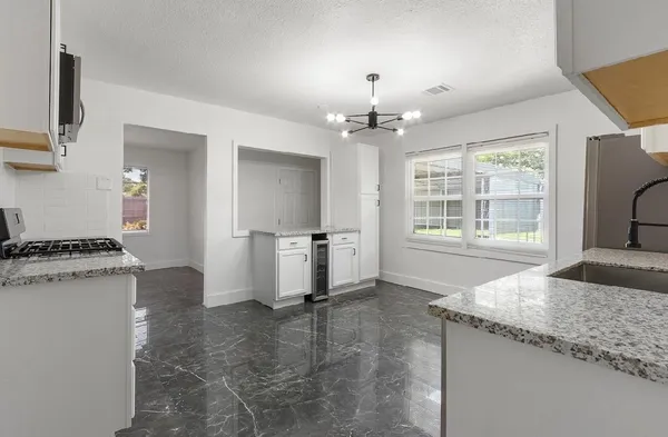 a kitchen with granite countertop a stove and a refrigerator