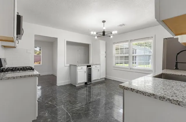 a kitchen with granite countertop a stove and a refrigerator