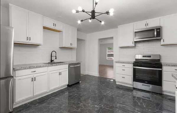 a kitchen with stainless steel appliances a stove sink and microwave