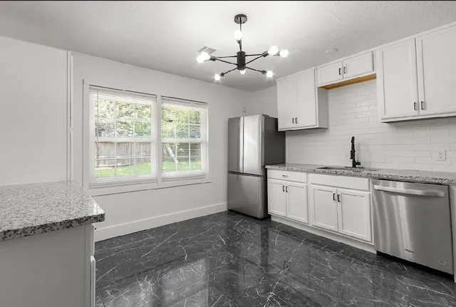 a kitchen with stainless steel appliances granite countertop a stove a sink dishwasher and a refrigerator