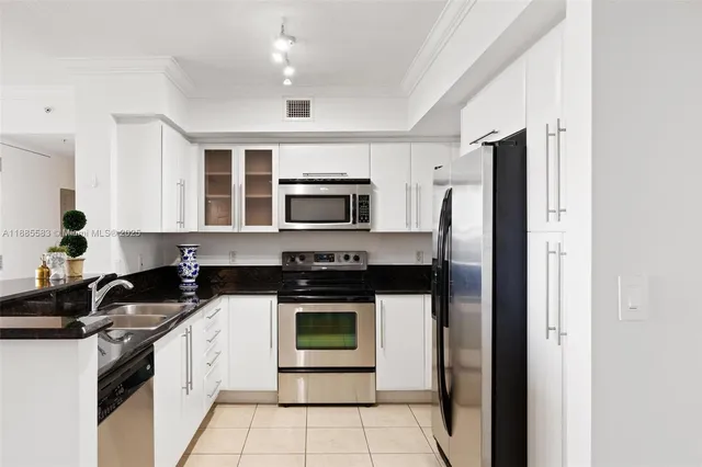 a kitchen with stainless steel appliances granite countertop a stove a sink and a refrigerator