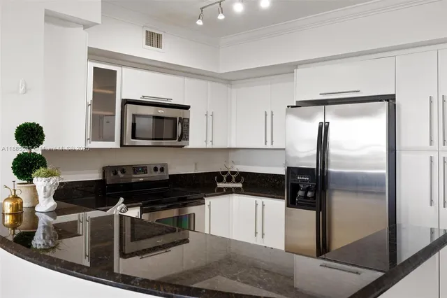 a kitchen with a sink a microwave a refrigerator and cabinets