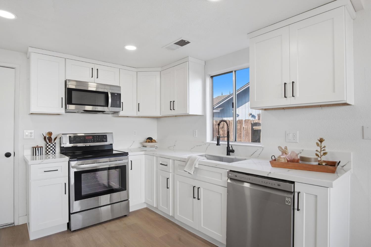 1732 Walpole Drive Modesto, CA 95358 - Photo 5 of 21 a kitchen with white cabinets and stainless steel appliances