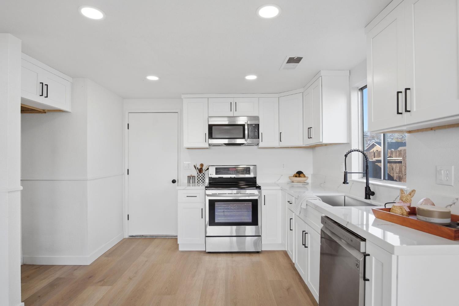 1732 Walpole Drive Modesto, CA 95358 - Photo 6 of 21 a kitchen with granite countertop white cabinets and stainless steel appliances