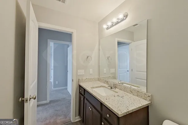 a bathroom with a granite countertop sink and a mirror