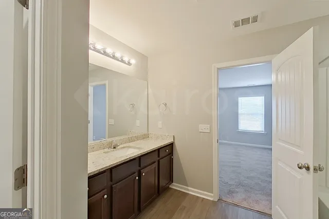 a bathroom with a granite countertop sink and a mirror