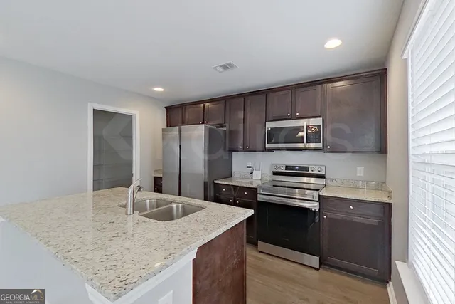 a kitchen with kitchen island a sink stove and refrigerator