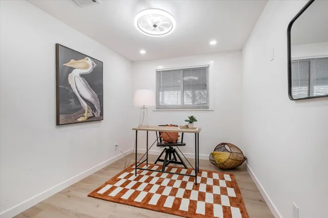 a view of a workspace room with wooden floor