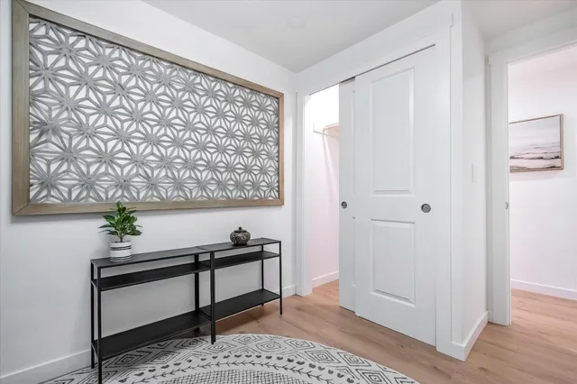 a view of a hallway with wooden floor and a potted plant