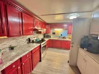 a kitchen with stainless steel appliances granite countertop a sink stove and cabinets