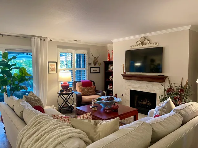 a living room with furniture a fireplace and a flat screen tv