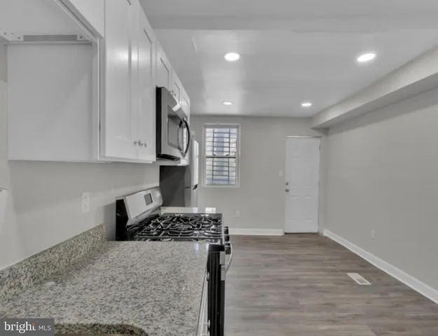 a kitchen with stainless steel appliances granite countertop a stove a refrigerator and a sink