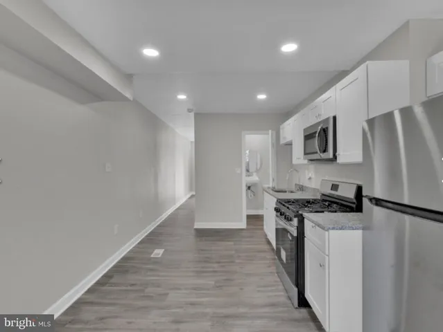 a kitchen with granite countertop a stove top oven and cabinets