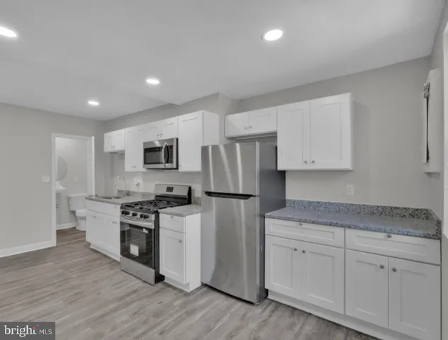 a kitchen with white cabinets and stainless steel appliances