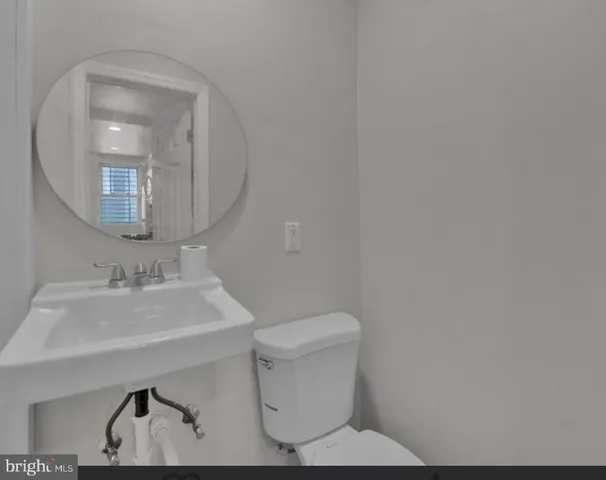 a bathroom with a toilet a sink and mirror