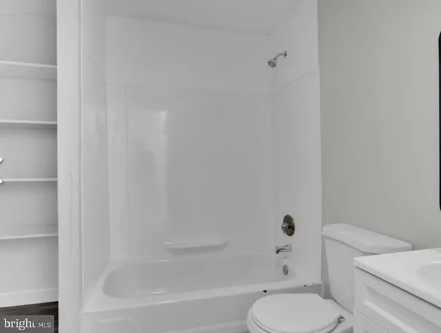 a white toilet sitting next to a bath tub