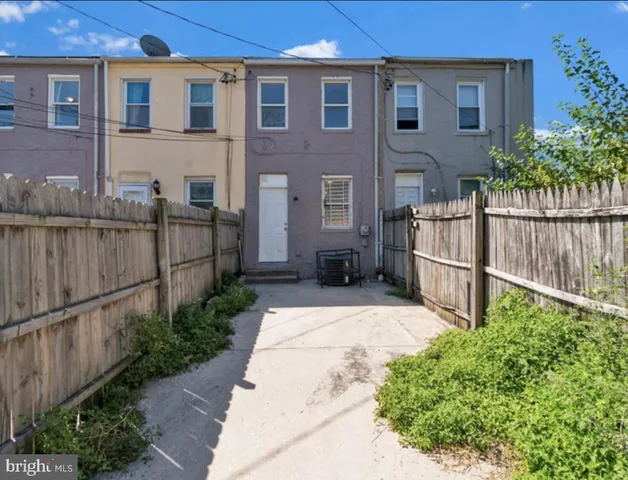 a view of a brick house with wooden fence