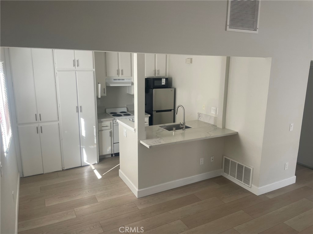 3703 Country Oaks Loop, Unit B Ontario, CA 91761 - Photo 12 of 30 a view of kitchen with refrigerator and cabinets