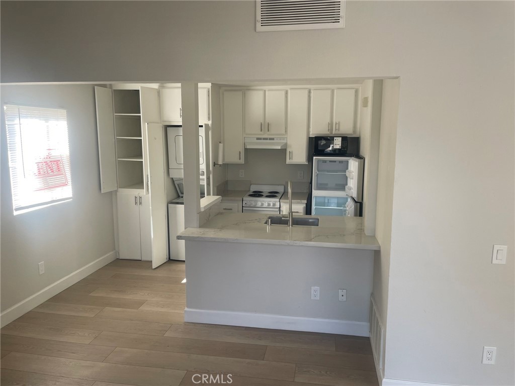 3703 Country Oaks Loop, Unit B Ontario, CA 91761 - Photo 14 of 30 a room with stainless steel appliances a refrigerator a sink a stove a microwave and cabinets