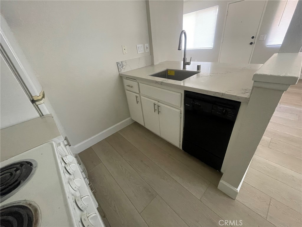 3703 Country Oaks Loop, Unit B Ontario, CA 91761 - Photo 18 of 30 a kitchen with a sink and a stove top oven