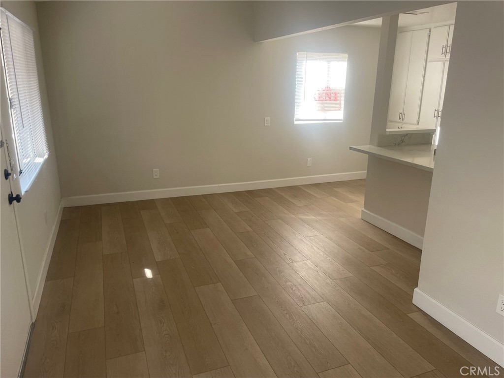 3703 Country Oaks Loop, Unit B Ontario, CA 91761 - Photo 10 of 30 an empty room with wooden floor and windows
