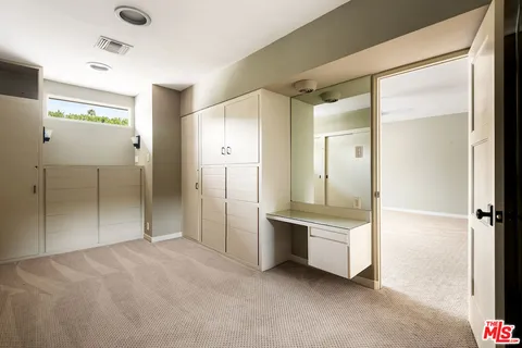 a view of a hallway with closet and wooden floor