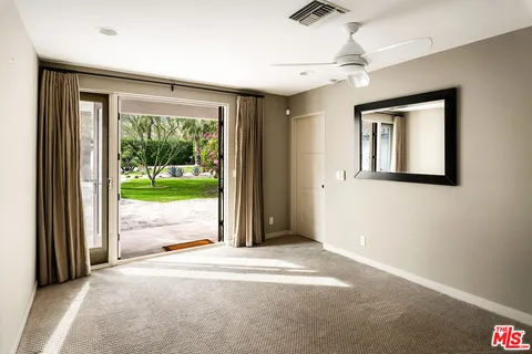 en empty room with windows and ceiling fan