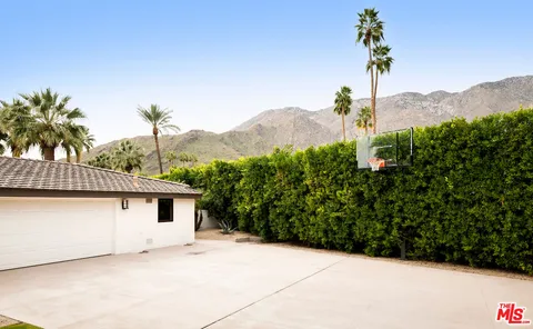 a front view of a house with a yard and mountain