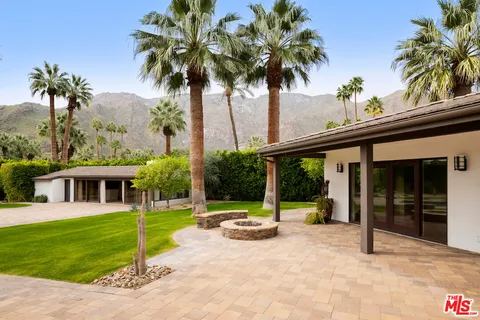 a view of a house with a swimming pool and a porch with furniture