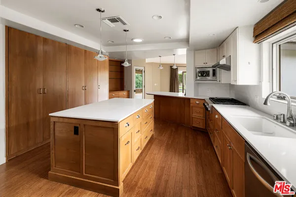 a kitchen with stainless steel appliances granite countertop a sink a stove and a refrigerator