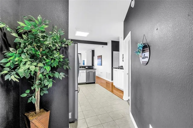 a view of a hallway to potted plants and wooden floor