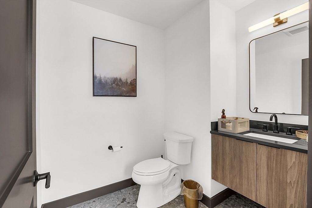 36 Vantage Point Drive, Unit 4 Laconia, NH 03246 - Photo 23 of 42 a bathroom with a granite countertop toilet sink and mirror