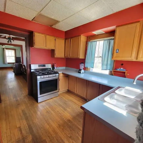 a kitchen with stainless steel appliances granite countertop a stove a sink and a microwave