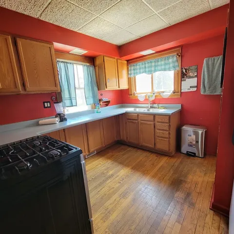a kitchen with stainless steel appliances granite countertop a sink and wooden cabinets
