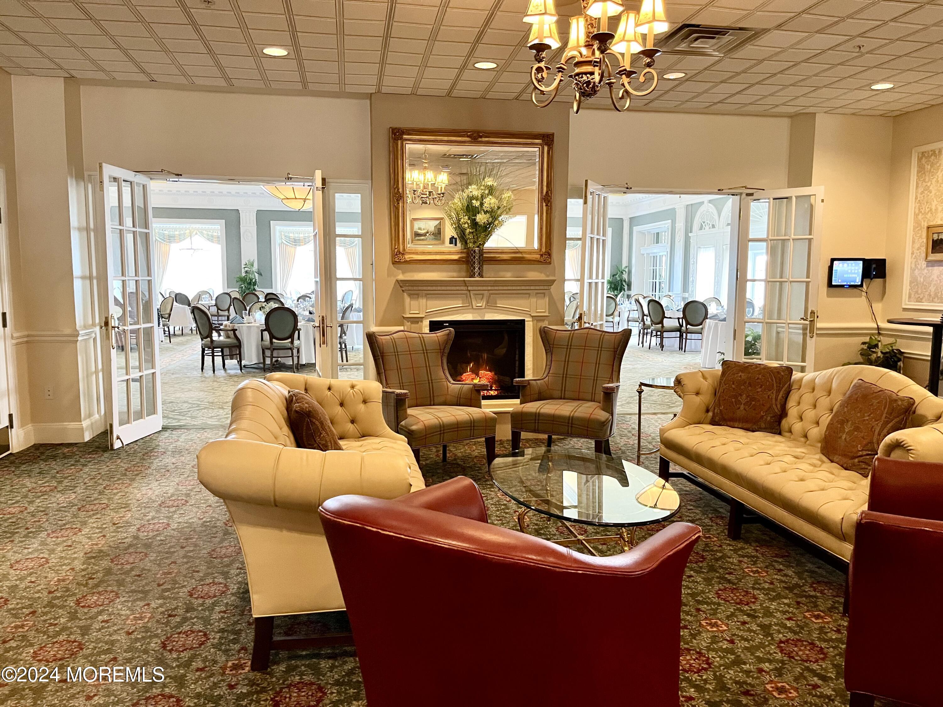 700 Ocean Avenue, Unit G38 Spring Lake, NJ 07762 - Photo 37 of 37 a living room with furniture a chandelier and a fireplace