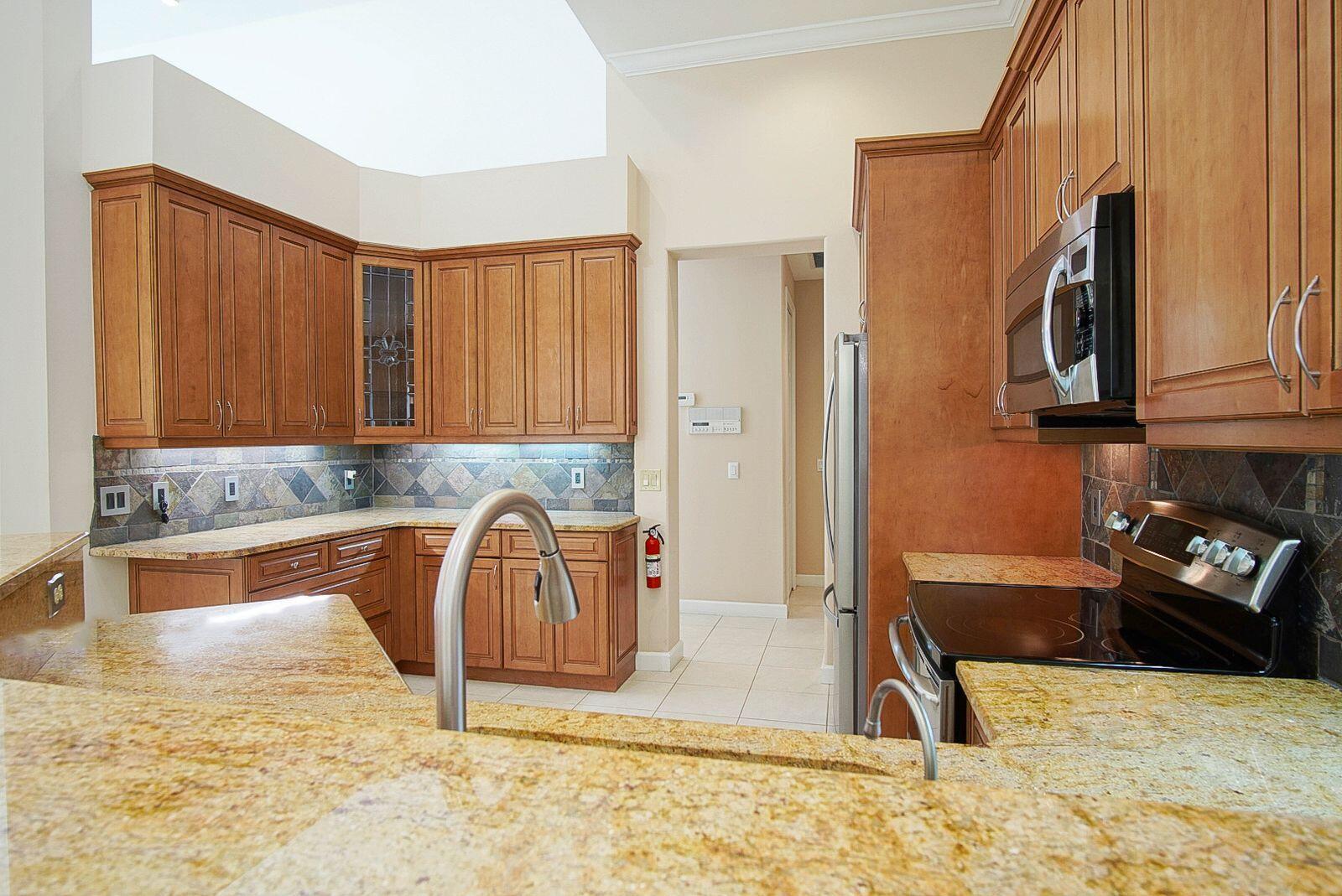 5496 Southeast Reef Way Stuart, FL 34997 - Photo 14 of 35 a kitchen with stainless steel appliances granite countertop a refrigerator a stove a sink and dishwasher