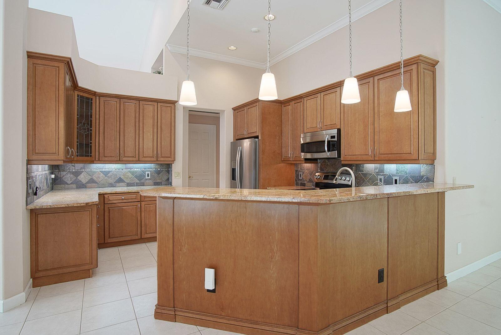 5496 Southeast Reef Way Stuart, FL 34997 - Photo 15 of 35 a kitchen with stainless steel appliances granite countertop a sink and cabinets