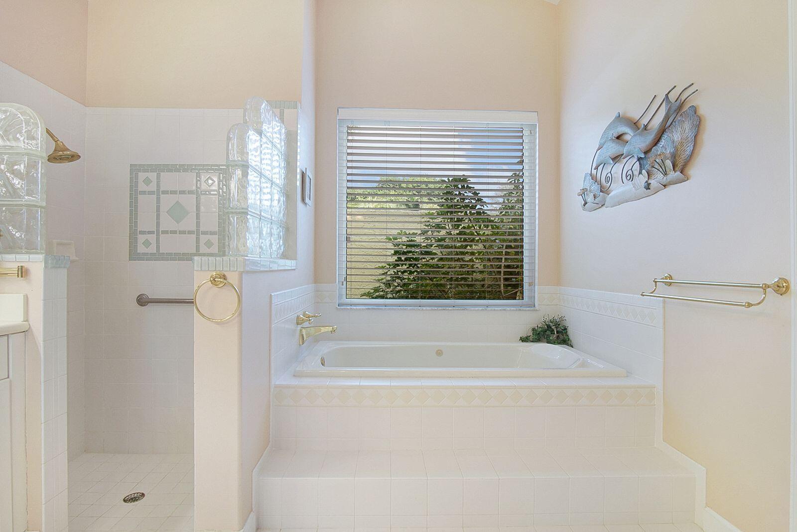 5496 Southeast Reef Way Stuart, FL 34997 - Photo 18 of 35 a bathroom with a bathtub and a shower