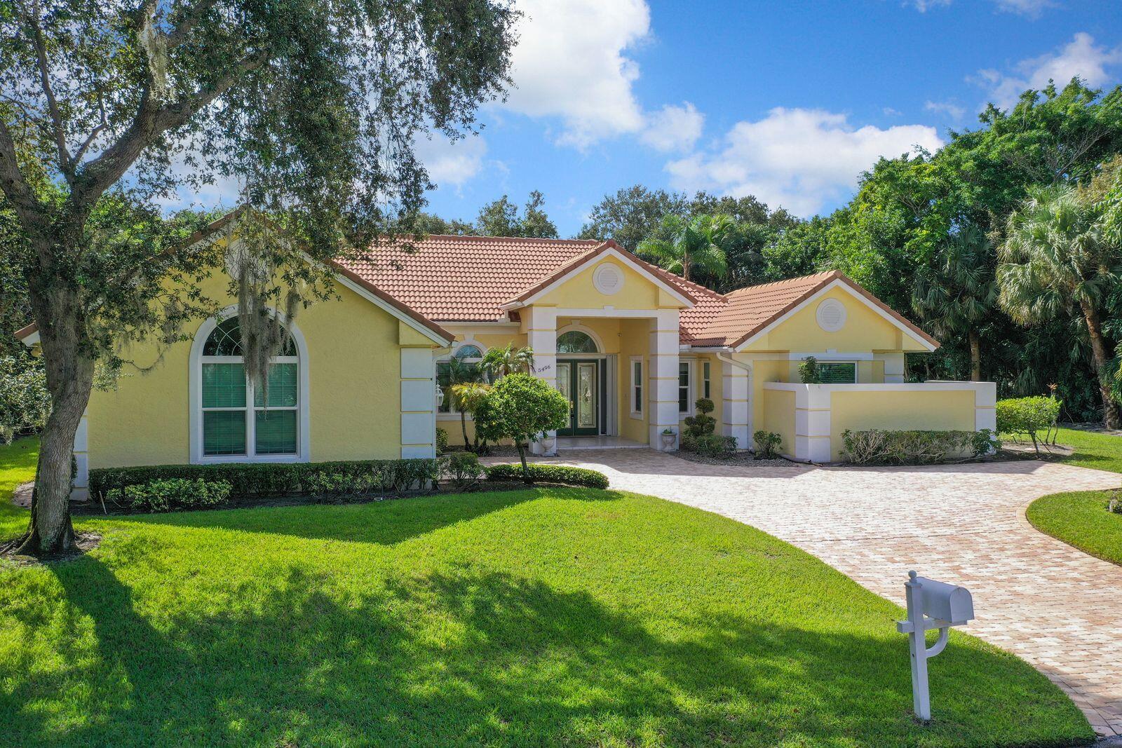 5496 Southeast Reef Way Stuart, FL 34997 - Photo 2 of 35 a front view of a house with a yard and porch
