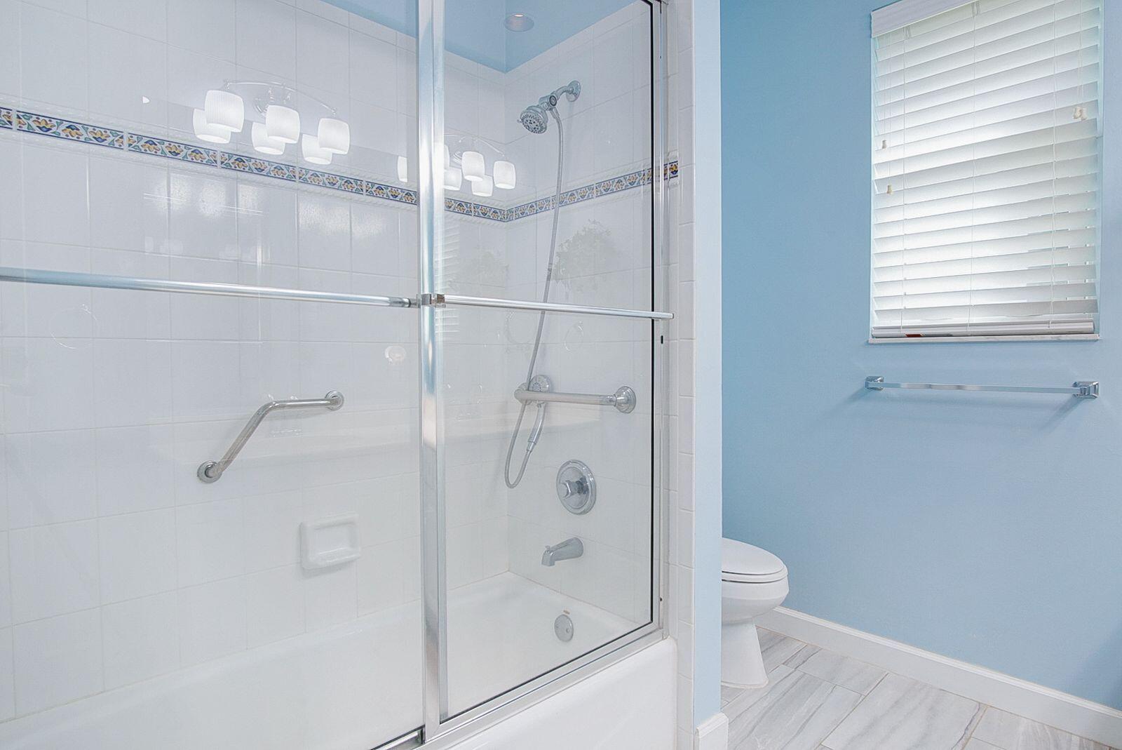 5496 Southeast Reef Way Stuart, FL 34997 - Photo 21 of 35 a bathroom with a glass shower door
