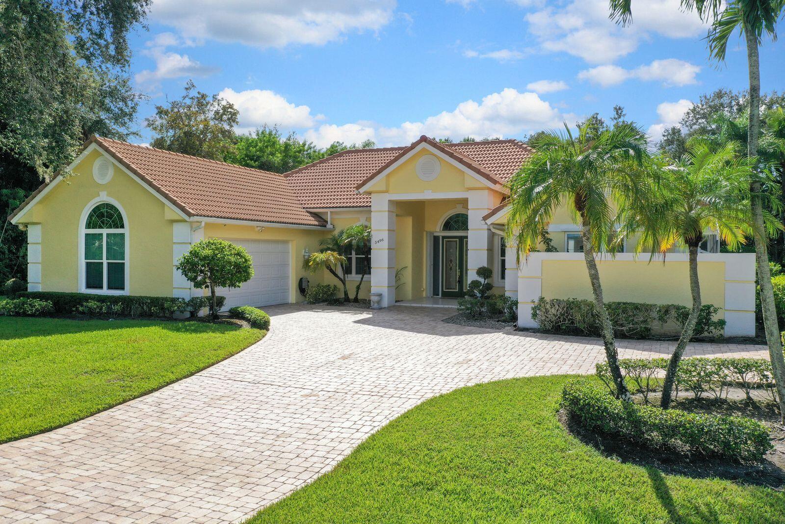 5496 Southeast Reef Way Stuart, FL 34997 - Photo 31 of 35 a front view of a house with a garden and plants