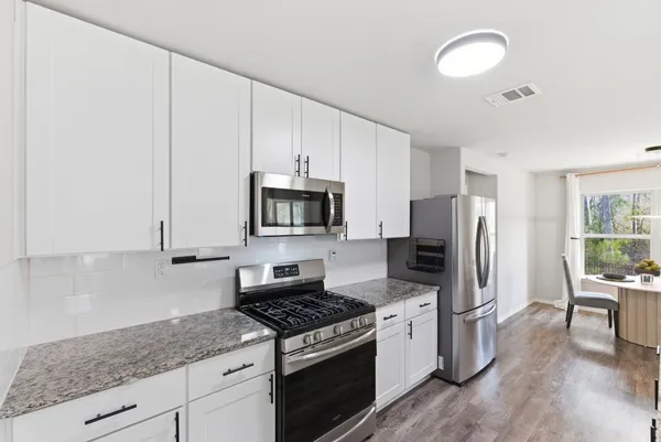 a kitchen with stainless steel appliances granite countertop a stove a sink and a refrigerator