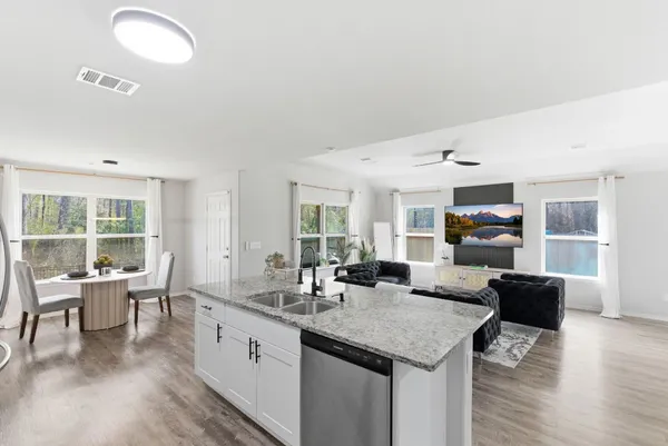 a living room with furniture and a kitchen view
