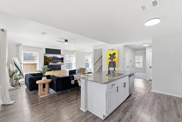 a living room with stainless steel appliances kitchen island granite countertop a couch and a view of kitchen
