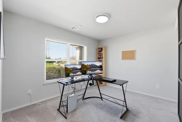 a view of a workspace with furniture and a window