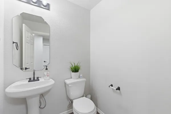 a bathroom with a toilet a sink and mirror